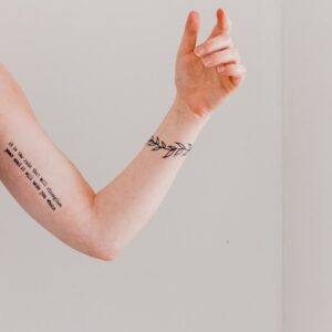 person showing arm and wrist tattoo