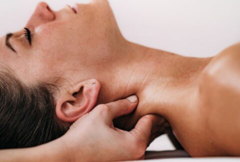 Therapist demonstrating neck and shoulder massage techniques taught on a massage therapy course