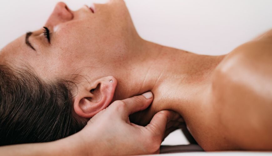 Therapist demonstrating neck and shoulder massage techniques taught on a massage therapy course