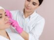 Beauty professional carrying out an aesthetic facial treatment on a client