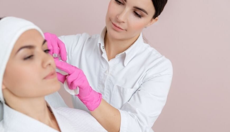 Beauty professional carrying out an aesthetic facial treatment on a client